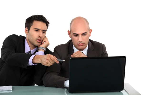 Executivos discutindo conteúdo em um laptop — Fotografia de Stock