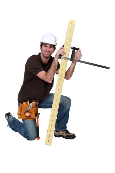 Een timmerman met een plank. — Stockfoto