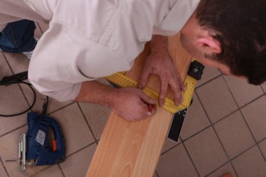 Carpenter measuring wood clipart
