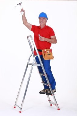 Electrician working on ceiling clipart