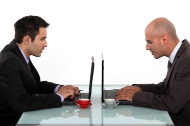 Profile of businessmen working at their laptops clipart