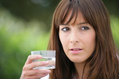 Brunette holding a glass of water clipart