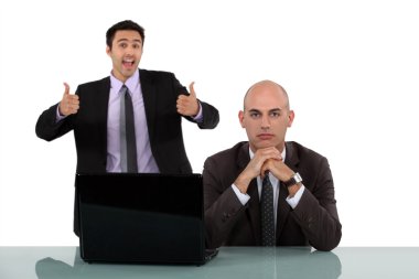 Man rejoicing behind his long-faced colleague clipart