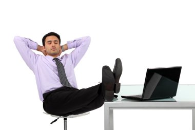 Businessman relaxing at his desk clipart