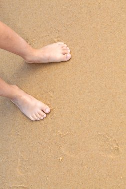 Bare feet on a sandy beach clipart