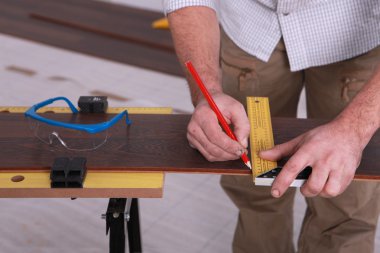 Man marking-off laminate flooring clipart