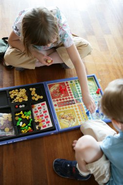 Brother and sister playing a board game clipart