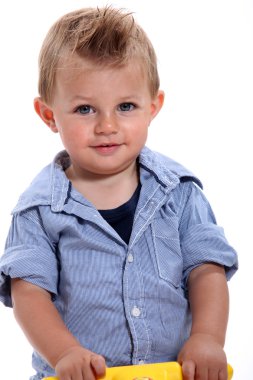 Closeup of a little boy with gelled hair using a walker clipart