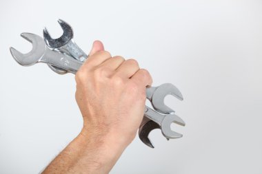 Closeup of a man's hand holding spanners clipart