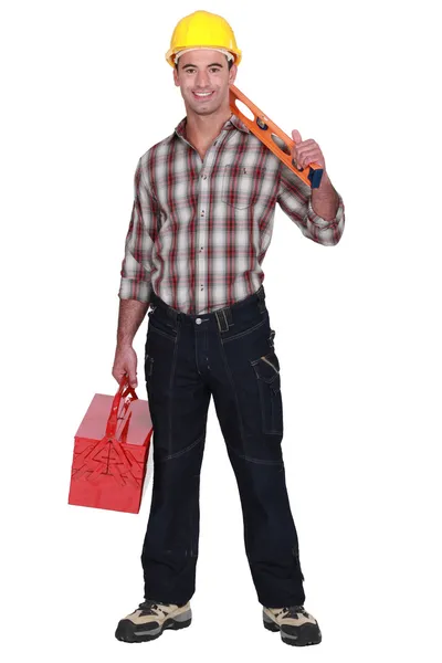 Construction worker holding a toolbox and spirit level — Stock Photo, Image