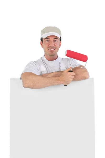 Decoratore maschio in piedi con poster in bianco — Foto Stock