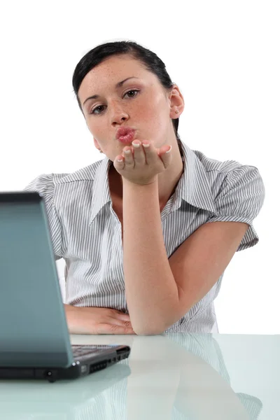 Mujer en escritorio soplando beso —  Fotos de Stock