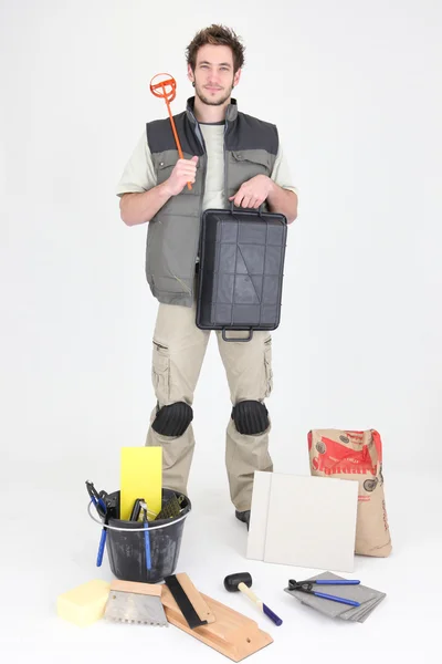 Professional tile fitter holding a mixer and a tray — Stock Photo, Image
