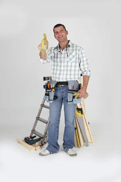 Timmerman staande door ladder geven de duimen omhoog — Stockfoto