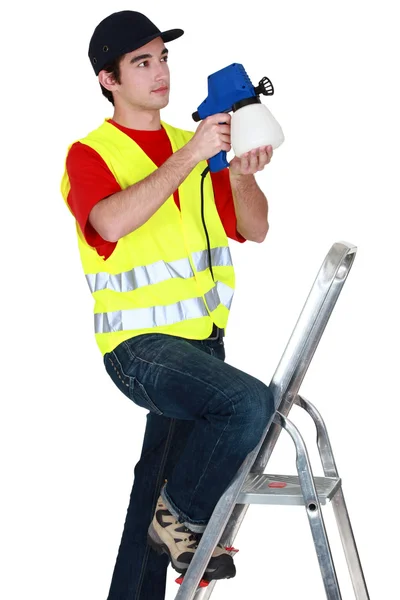 Unga arbetare på en stege med spray — Stockfoto