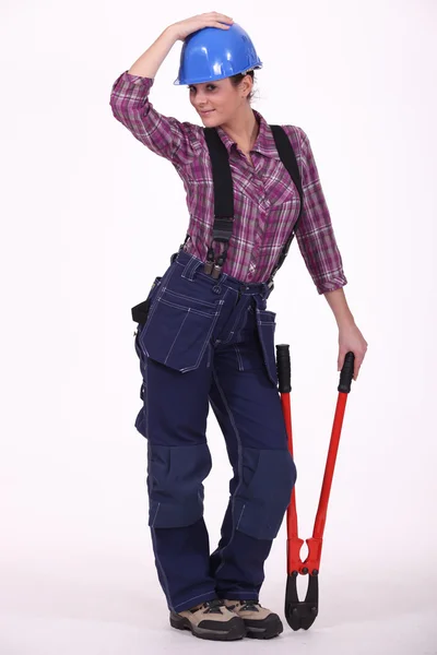 En kvinnlig byggnadsarbetare slående en pose — Stockfoto