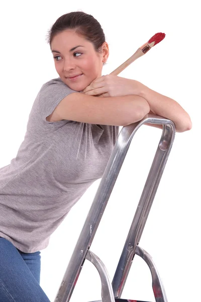 Frau hält beim Klettern der Leiter Pinsel in der Hand — Stockfoto
