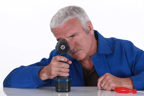 Grey haired handyman with cordless drill — Stock Photo, Image