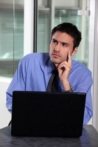 Pensive бізнесмен сидів зі своїм комп'ютером — стокове фото