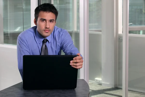 Hombre de negocios serio con un ordenador portátil — Foto de Stock