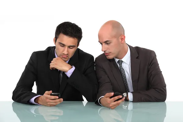 Businessmen comparing phones — Stock Photo, Image