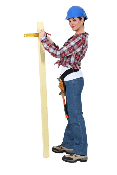 Žena měření šířku prkna dřeva — Stock fotografie