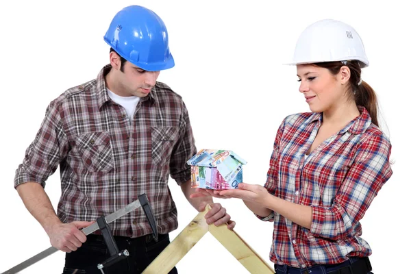 Builders with a house made out of money — Stock Photo, Image