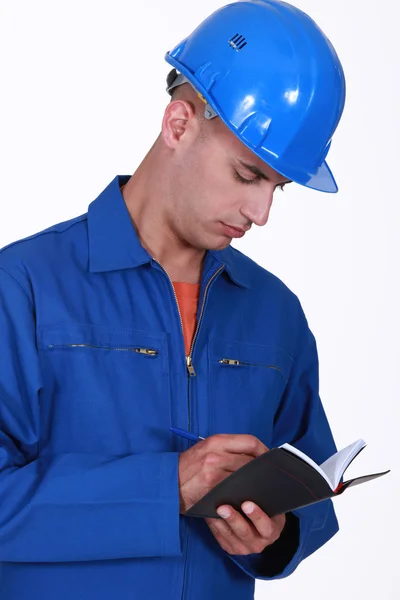 Tradesman writing in his agenda — Stock Photo, Image