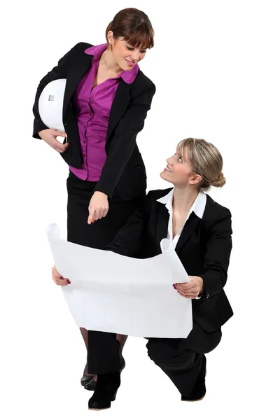 Две женщины-предпринимательницы, занимающиеся недвижимостью, рассматривают план — стоковое фото
