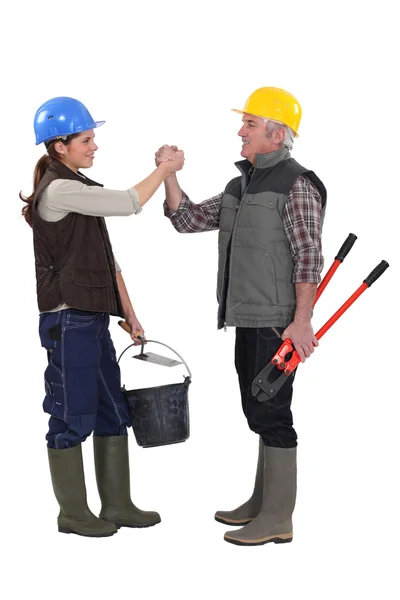 Trabalhadores manuais masculinos e femininos apertando as mãos — Fotografia de Stock