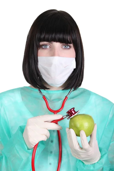 Female surgeon holding a green apple — Stock Photo, Image