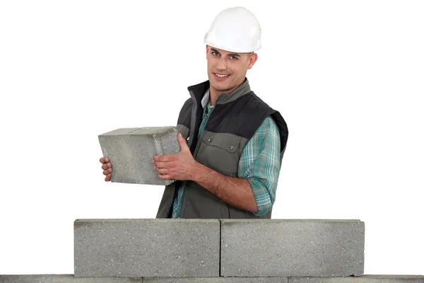 Bricklayer tenant bâtiment mur de béton — Photo