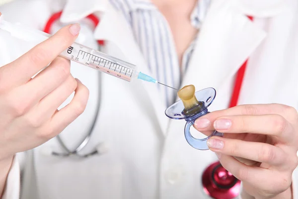 Enfermeira a injectar um medicamento numa chupeta — Fotografia de Stock