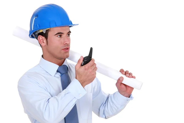 Ingenjör innehar en hoprullad plan och tala i en walkie-talkie — Stockfoto