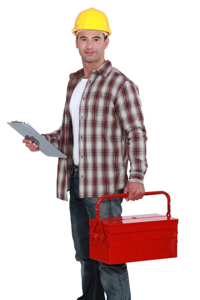 Construtor segurando clip-board e caixa de ferramentas — Fotografia de Stock