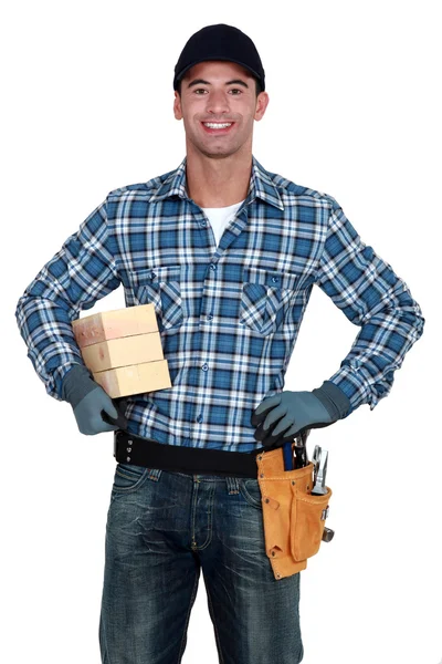 Trabalhador manual sorridente com madeira — Fotografia de Stock