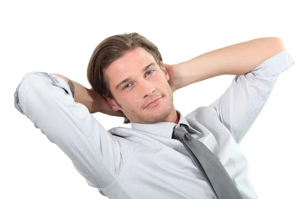 Young businessman sitting with arms behind head. — Stock Photo, Image