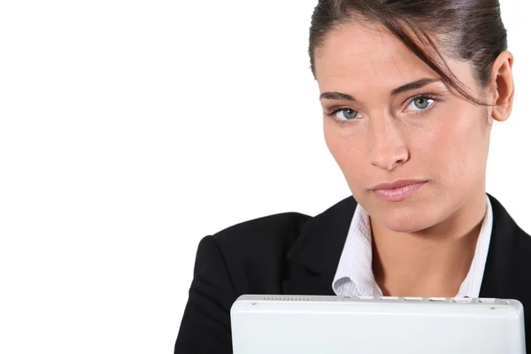Sério executivo feminino segurando laptop fechado — Fotografia de Stock