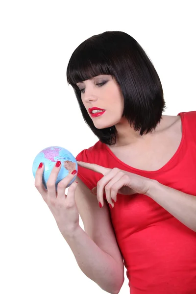 Брюнетка с миниатюрным глобусом — стоковое фото