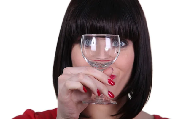 Woman watching meticulously an empty goblet — Stock Photo, Image