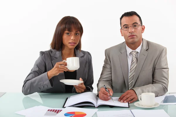 Uomo d'affari e donna d'affari che esaminano un progetto e bevono caffè — Foto Stock