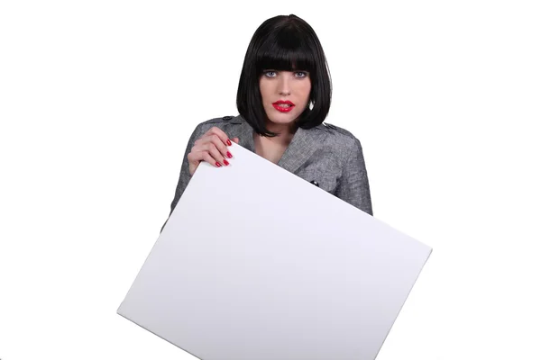 Brunette businesswoman holding a poster — Stock Photo, Image