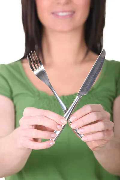 Kvinnan håller upp en kniv och en gaffel — Stockfoto