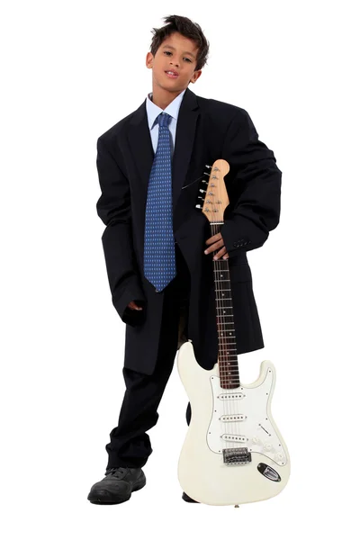 Boy in loose fitting suit stood with electric guitar — Stock Photo, Image