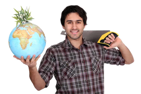 Man met een zaag en een globe — Stockfoto