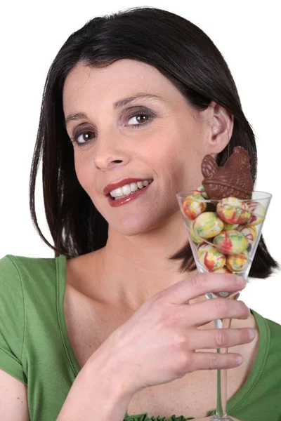 Mulher segurando um copo com ovos de chocolate de Páscoa — Fotografia de Stock