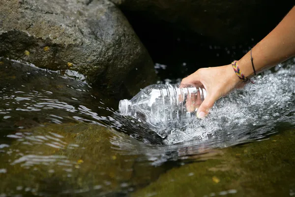 Llenar una botella de agua de plástico — Foto de Stock