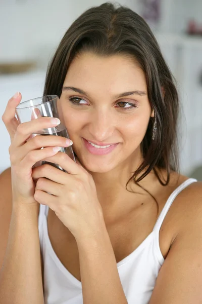 Morena segurando um copo de água — Fotografia de Stock