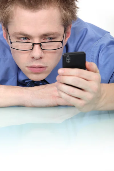 Чоловік уважно дивиться на свій мобільний телефон — стокове фото
