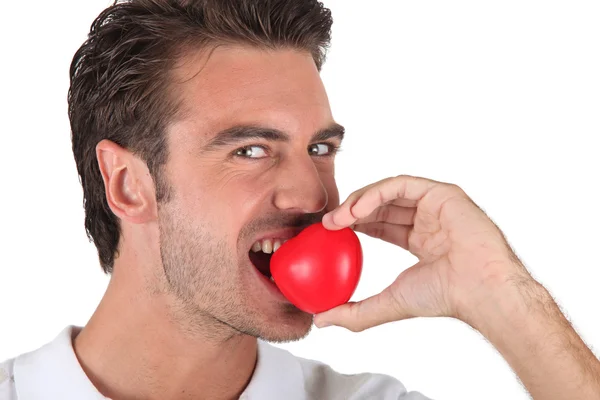 Man biting heart-shaped object — Stock Photo, Image